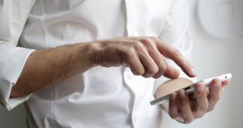 Comment savoir à qui appartient ce numéro gratuitement ? person holding white Android smartphone in white shirt