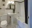 white ceramic toilet bowl beside pedestal sink