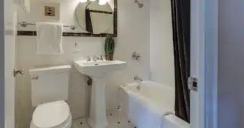 white ceramic toilet bowl beside pedestal sink